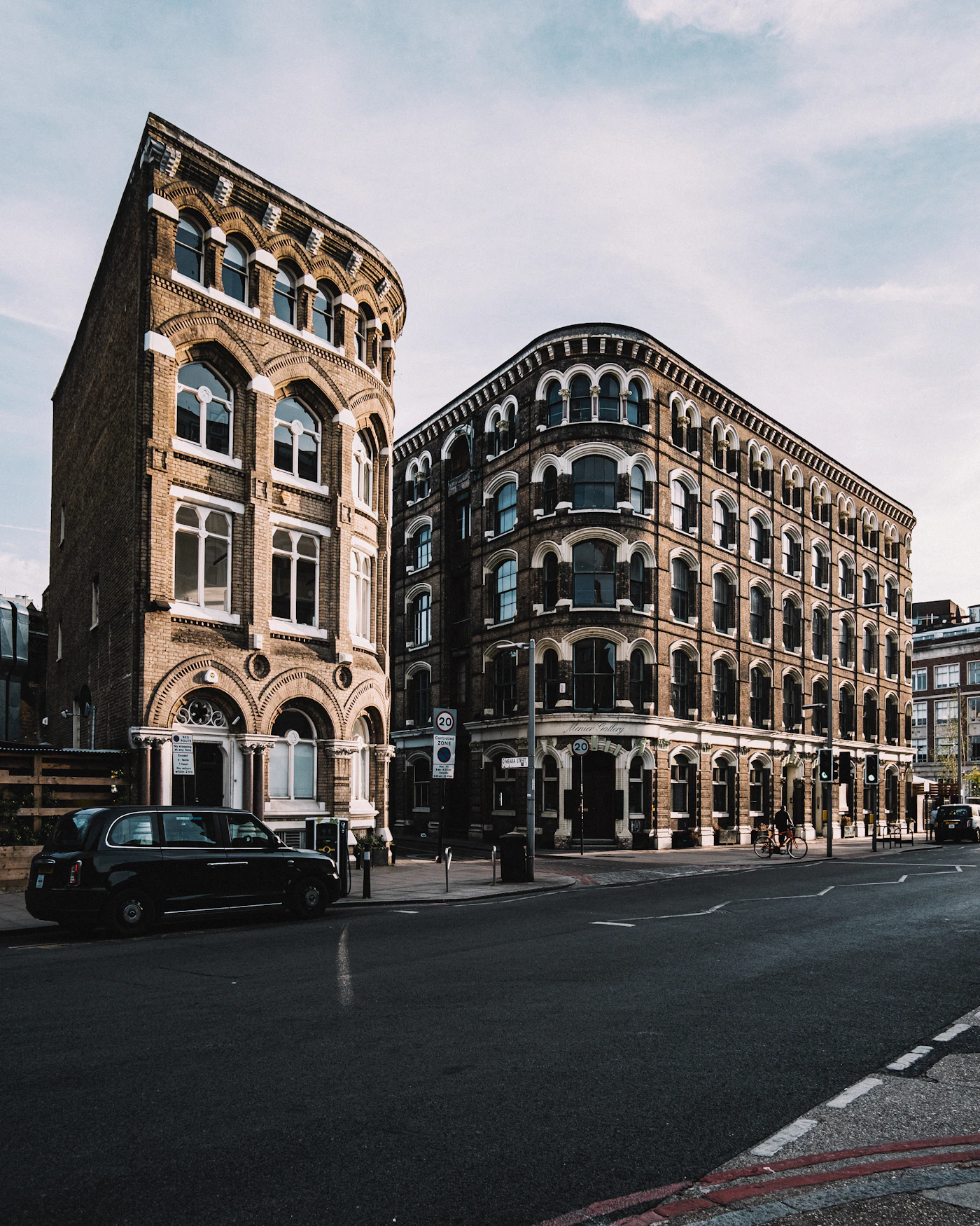 Victorian brick buildings and a black London taxi on Southwark Street, London