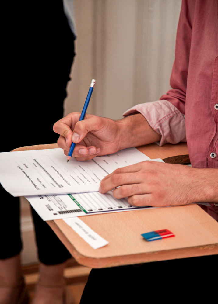 A candidate filling in an assessment paper with a pencil