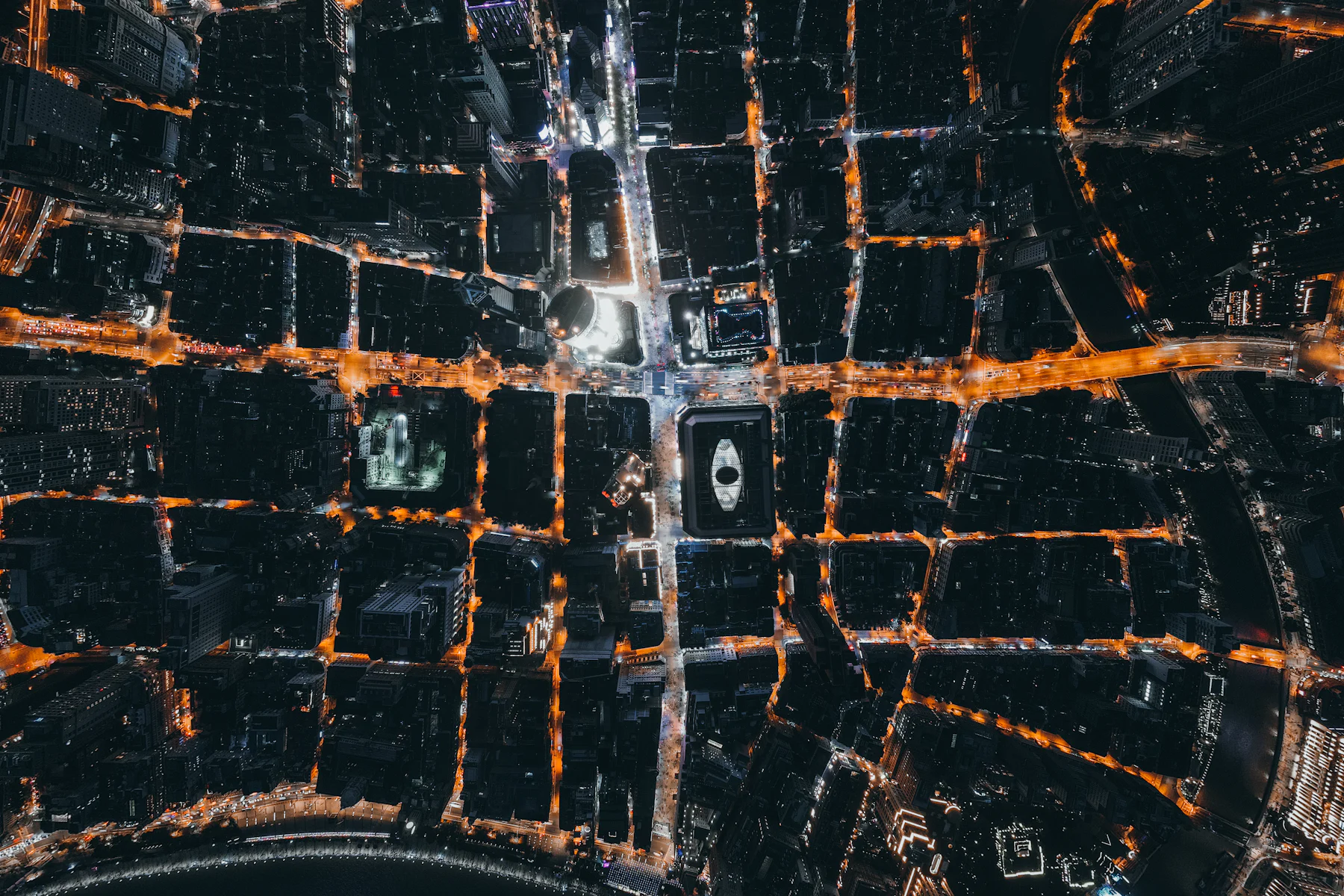Aerial night view of a city street network lit in orange